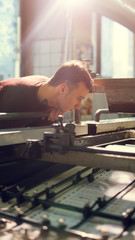 Wall Mural - Man controls wide industrial printer in workshop