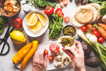 Wall Mural - Cooking healthy vegetarian food background. Vegetables, pesto and fruits on white background.