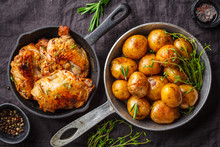 Grilled Chicken And Baked Potatoes In A Cast Iron Skillet.