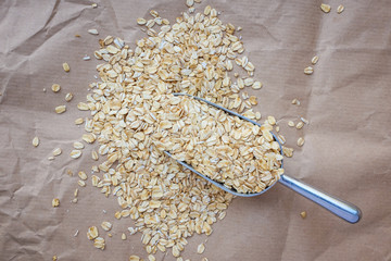 Wall Mural - Raw oat flakes in a metal scoop