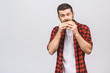 Young man holding a piece of hamburger. Student eats fast food. Burger is not helpful food. Very hungry guy. Diet concept isolated against white background.