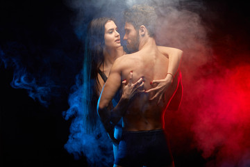 Wall Mural - sexy woman holding her man in embrace. the strength of love. isolated black background