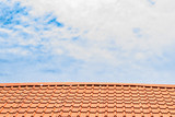 Fototapeta  - Red roof with a cloudy blue sky on top