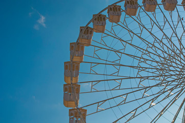 attraction Ferris wheel on the background of a beautiful blue sky