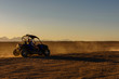 Unrecognizable people driving buggy during safari trip at sunset in Arabian desert not far from the Hurghada city, Egypt