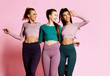 © Dmitry Lobanov - Fitness sport girls friends in blue, grey, brown walk together, talk and laugh. Girls in good shape on pink background
