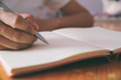 © Somkiat - Woman hand with pen writing on notebook.