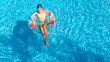 © Iuliia Sokolovska - Acrive girl in swimming pool aerial top view from above, kid swims on inflatable ring donut , child has fun in blue water on family vacation resort