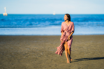 Portrait beautiful young asian woman smile happy walk on the tropical outdoor nature beach sea