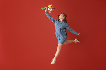 Wall Mural - Jumping woman with bouquet of flowers on color background