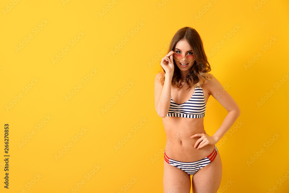 Beautiful young woman in swimsuit on color background - obrazy, fototapety, plakaty 