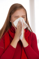 woman sneezes holding a handkerchief nasal