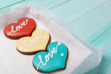 In The Box Are Three Colored Cakes In The Shape Of Hearts, On Turquoise Boards, The Concept Of Celebration