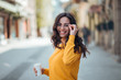 © bnenin - Beautiful young woman with takeaway coffee walking in the city on a sunny day.