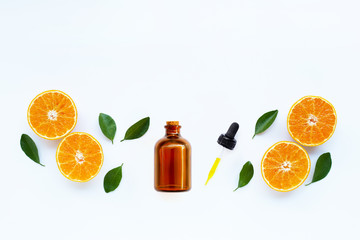 Essential oil with orange fruits with leaves on white background.