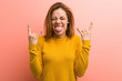 © Asier - Young pretty young woman showing rock gesture with fingers
