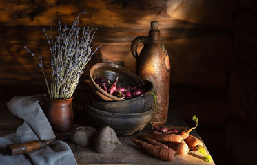 still life in a village hut. old ceramic dishes and vegetables on the table in the morning sun