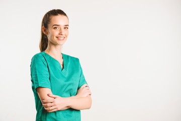 Cheerful female doctor in green uniform.