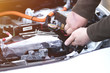 © Андрей Репетий - Mechanic checking the car fuse of electric car.