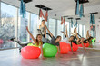© RomanR - Group of people in gym exercising with fit ball