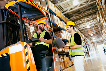 Warehouse workers working together with forklift loader