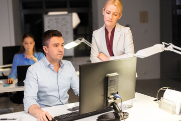 Poster - business, deadline and technology concept - coworkers with computer working late at night office