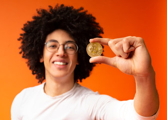 Poster - Golden bitcoin in african-american man hand closeup