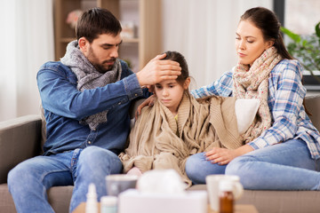 Wall Mural - family, health and people concept - father, mother and ill daughter having fever at home