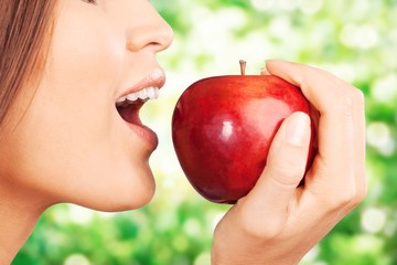 Young woman holding fresh apple on white background