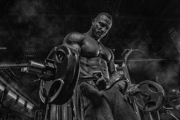 Sexy muscular man in gym, shaped abdominal. Strong male naked torso abs, working out. Dark background.