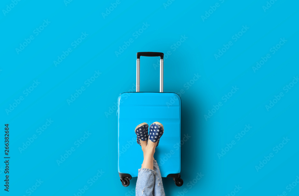 Blue suitcase on the blue background - obrazy, fototapety, plakaty 