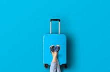 Blue Suitcase On The Blue Background