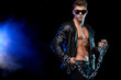 © Mike Orlov - Men fashion. Close-up portrait of a brutal and fit man topless in a leather jacket with chains. Athlete bodybuilder on black background.