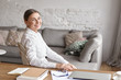 © shurkin_son - People, aging, technology, occupation and lifestyle concept. Indoor shot of cheerful beautiful senior businesswoman in white shirt working from home office, sitting at desk and smiling happily
