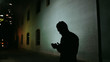 © Daniel Lies (lees)/Stocksy - Silhouetted man checking his phone
