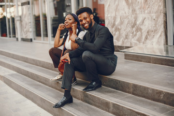 A stylish and beautiful dark-skinned couple in a city