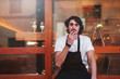 © Bonninstudio/Stocksy - Portrait of a waiter smoking in front of a restaurant.