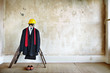 © James Ross Photography/Stocksy - Suit, tie, shoes hard hat in an bare room