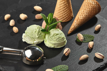 Wall Mural - Gourmet chocolate and pistachio ice cream served on a stone slate over a black background.