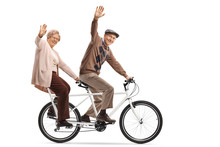 Senior Couple Riding A Tandem Bycicle And Waving