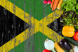 Fresh vegetables from Jamaica on table. Cooking concept on wooden flag background.