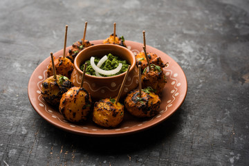 Wall Mural - Tandoori aloo are roasted potatoes with Indian spices. It's a party appetiser served with green chutney. selective focus