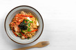 © Arnut - top view of stir fried egg noodles with kimchi in a ceramic dish. asian homemade style food concept.