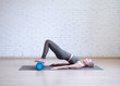 © junky_jess - Gluteal bridge on foam roller. Young caucasian woman doing pilates with special equipment in fitness studio.