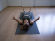 © junky_jess - The shavasana. Woman laying on mat in relaxing pose on the floor, yoga class, front view