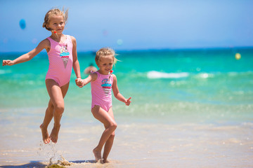 Adorable little girls having fun during beach vacation