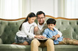 © imtmphoto - asian father and two children reading book together