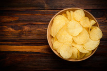 Potato Chips In Bowl On Dark Wooden Table
