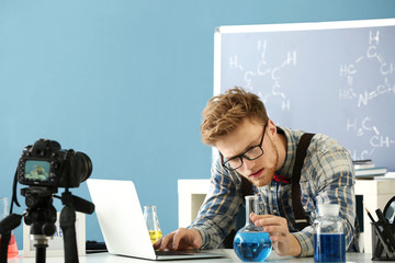 Wall Mural - Young male blogger recording video in laboratory