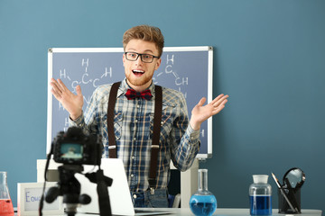 Wall Mural - Young emotional blogger recording video in laboratory